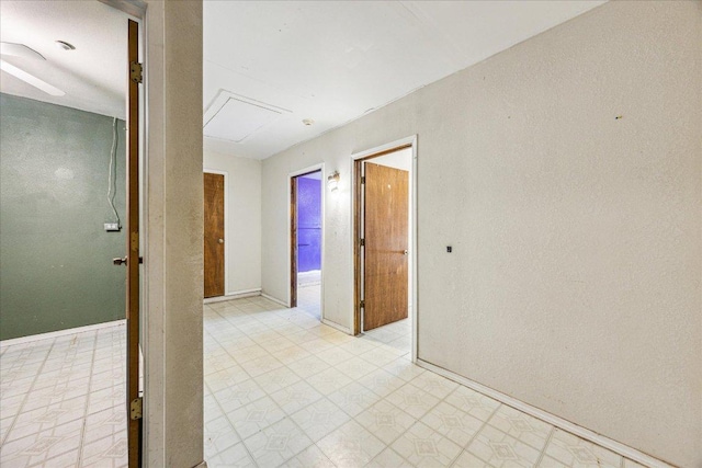 spare room featuring light floors and baseboards