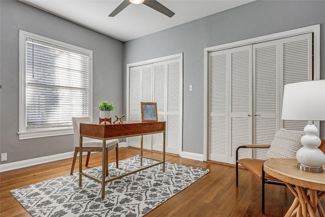 home office featuring baseboards, a ceiling fan, and wood finished floors