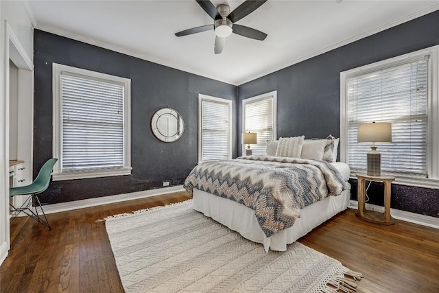 bedroom featuring ornamental molding, wood-type flooring, baseboards, and a ceiling fan