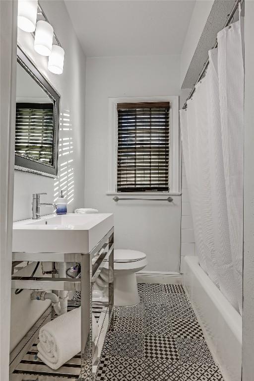 full bath with baseboards, shower / bathtub combination with curtain, toilet, and tile patterned floors