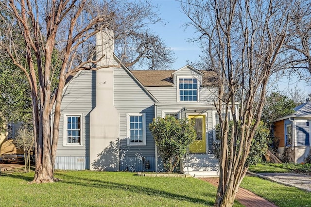 view of front of house with a shingled roof and a front lawn