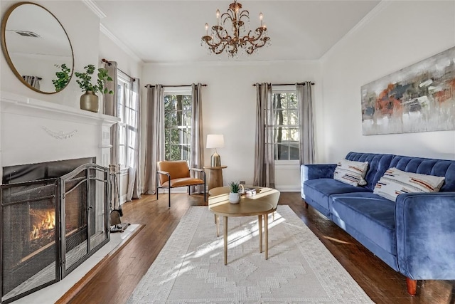 living room featuring ornamental molding, a warm lit fireplace, and wood finished floors