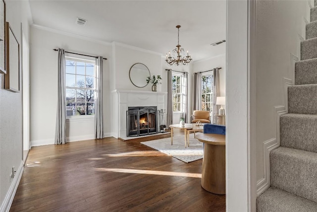 1709 Newfield Ln, Austin, TX 78703 - unfurnished living room featuring wood finished floors, a chandelier, a warm lit fireplace, crown molding, and stairway
