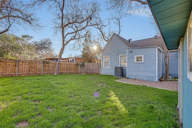 view of yard with central AC and a fenced backyard