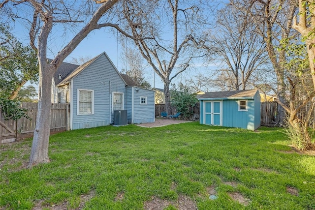 view of yard with central air condition unit, a fenced backyard, a shed, and an outdoor structure