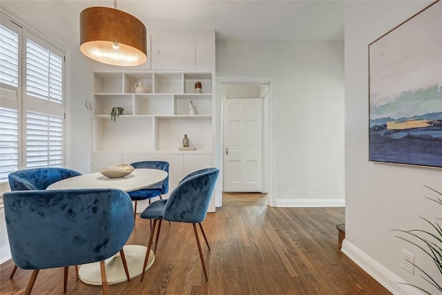 dining space with plenty of natural light, baseboards, and wood finished floors