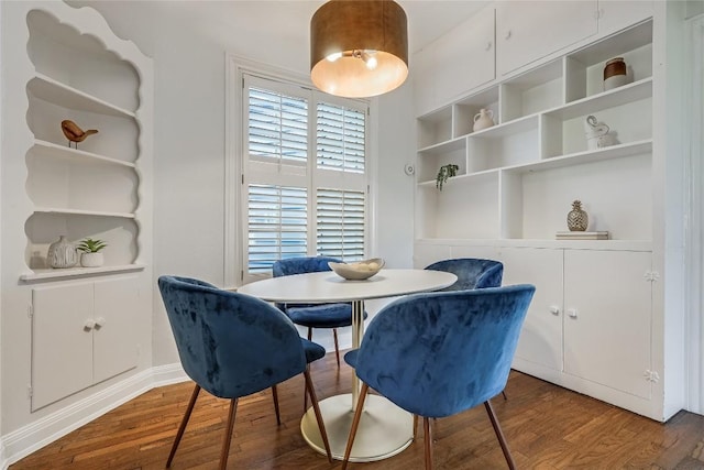 dining space featuring built in shelves and wood finished floors