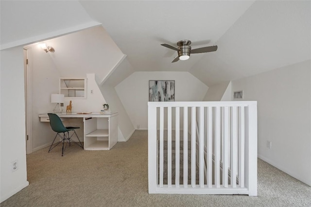 carpeted home office with visible vents, vaulted ceiling, and ceiling fan