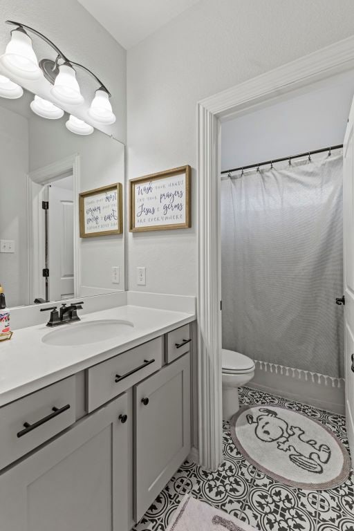 full bath featuring toilet, a shower with shower curtain, vanity, and tile patterned floors