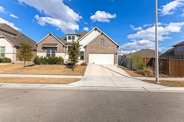 view of front facade featuring concrete driveway, brick siding, and fence