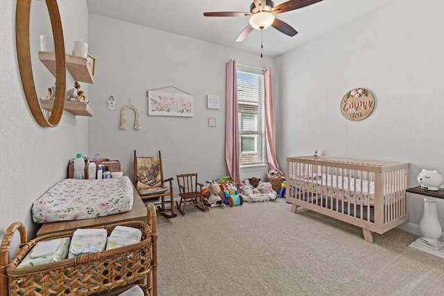 bedroom featuring ceiling fan, carpet floors, and a crib