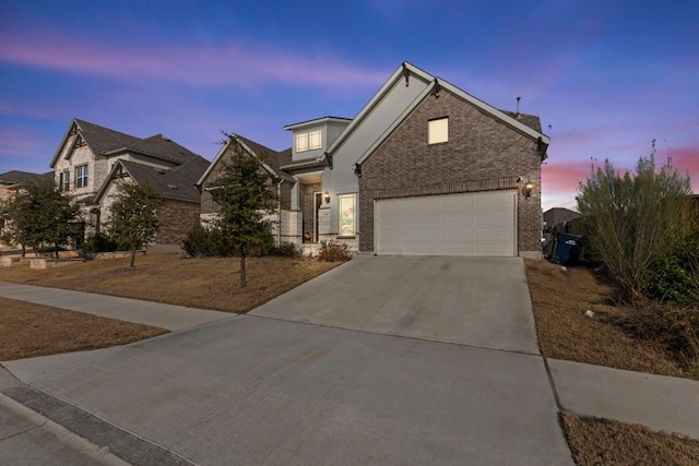 traditional home featuring brick siding, driveway, and an attached garage