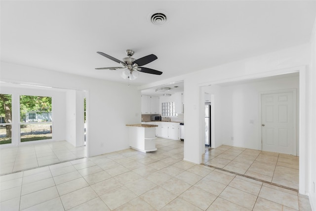 unfurnished living room with light tile patterned floors, visible vents, and a wealth of natural light