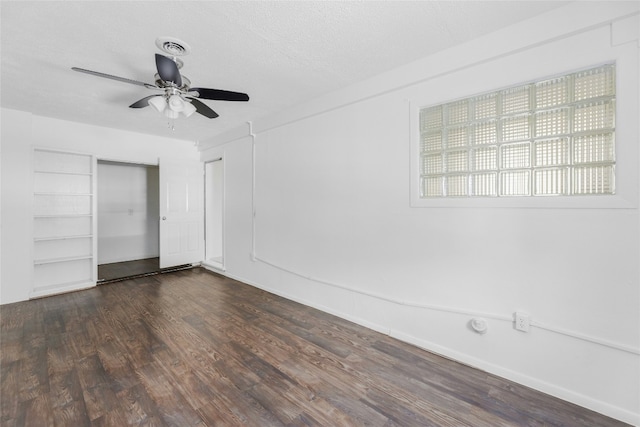 unfurnished bedroom featuring dark wood finished floors, a closet, visible vents, ceiling fan, and a textured ceiling