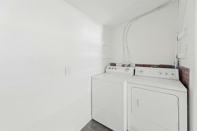 clothes washing area featuring laundry area, dark wood-style floors, and washer and clothes dryer