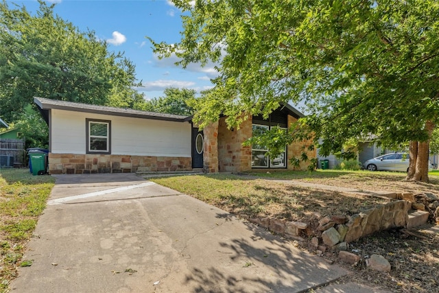 single story home with stone siding and a front lawn