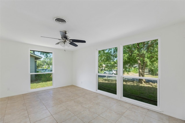 spare room with light tile patterned floors, ceiling fan, and visible vents