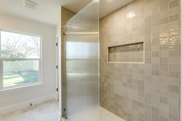 bathroom featuring a walk in shower, tile patterned flooring, visible vents, and baseboards