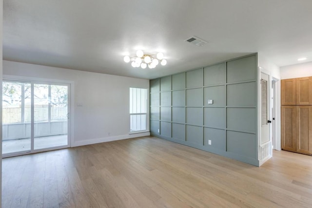 spare room with light wood-type flooring, baseboards, and visible vents