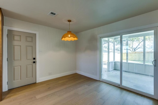 interior space featuring light wood-type flooring, visible vents, and baseboards