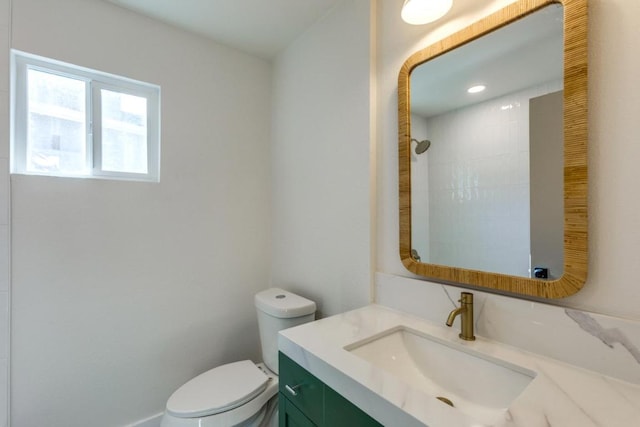 full bath with tiled shower, vanity, and toilet