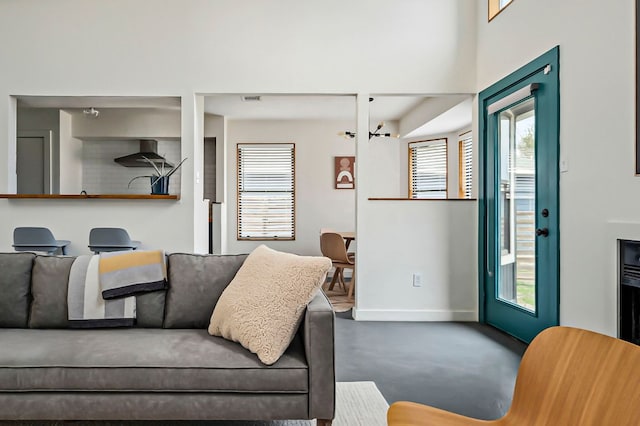 living area with concrete floors and baseboards