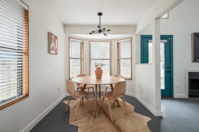 dining area with a chandelier, a wealth of natural light, and baseboards