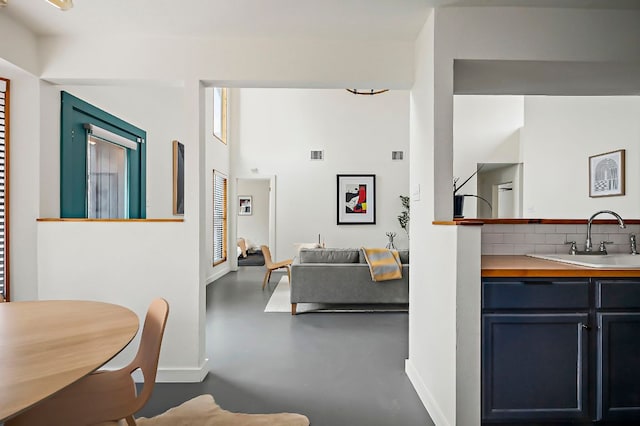 interior space featuring finished concrete flooring, visible vents, and baseboards