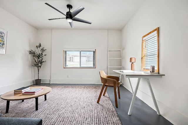 office space with a ceiling fan, concrete floors, and baseboards