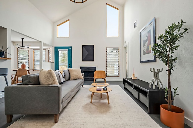 living room with high vaulted ceiling, a fireplace, and visible vents