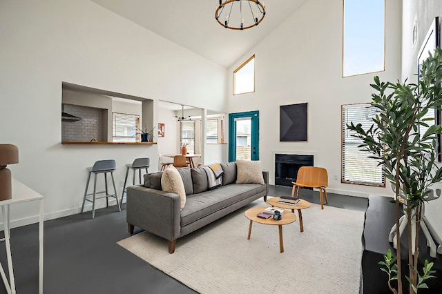 living area with plenty of natural light, a fireplace, a chandelier, and baseboards