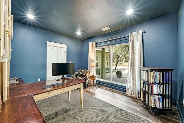 home office featuring wood finished floors, visible vents, recessed lighting, a textured ceiling, and a textured wall