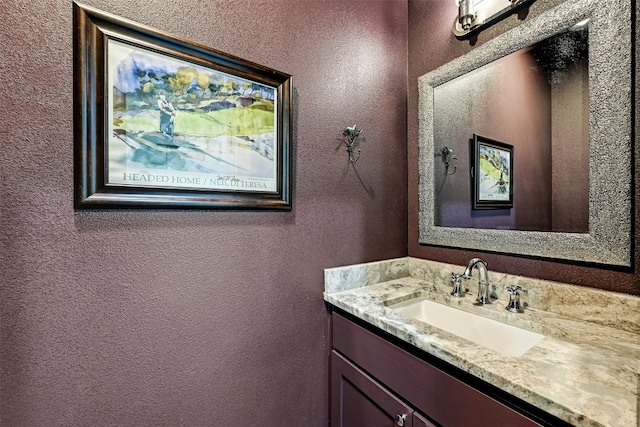bathroom with vanity and a textured wall
