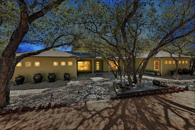 back of property at dusk with a patio area