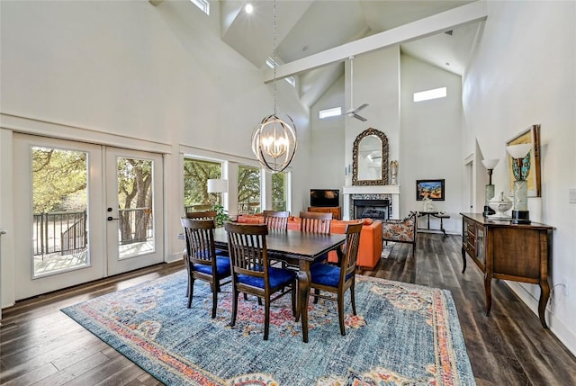 dining room with a fireplace, french doors, dark wood-style flooring, and a chandelier