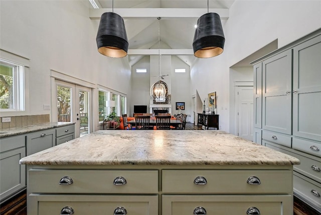 kitchen featuring beam ceiling, high vaulted ceiling, gray cabinetry, and a center island