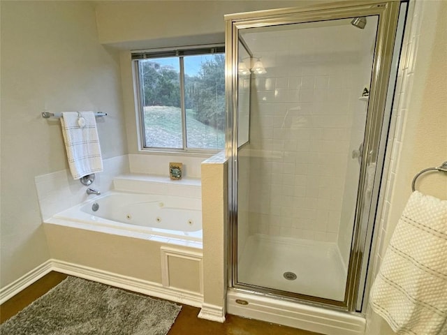 full bath with a stall shower, baseboards, and a tub with jets