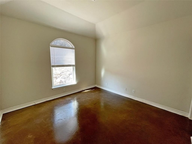 empty room with concrete floors and baseboards