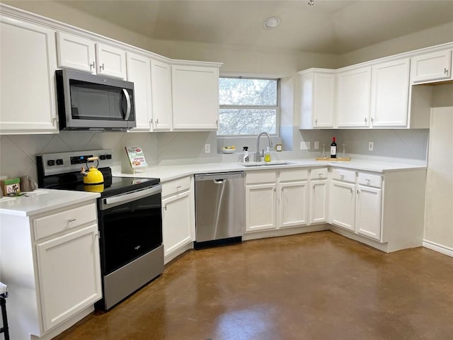 kitchen featuring light countertops, decorative backsplash, appliances with stainless steel finishes, white cabinets, and a sink