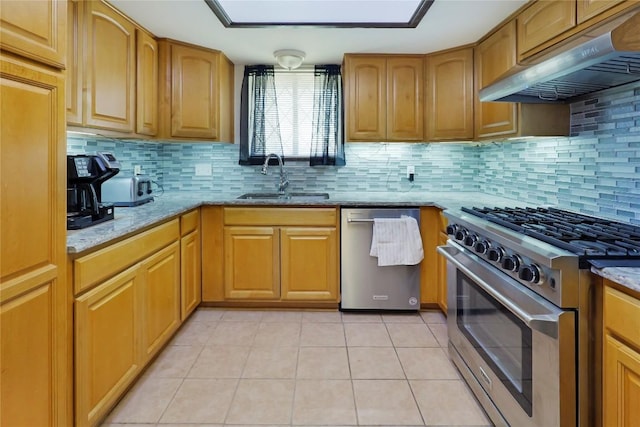 kitchen with under cabinet range hood, light stone counters, stainless steel appliances, and a sink