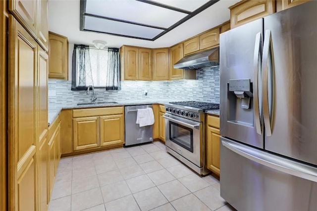 kitchen featuring light stone countertops, under cabinet range hood, appliances with stainless steel finishes, and a sink