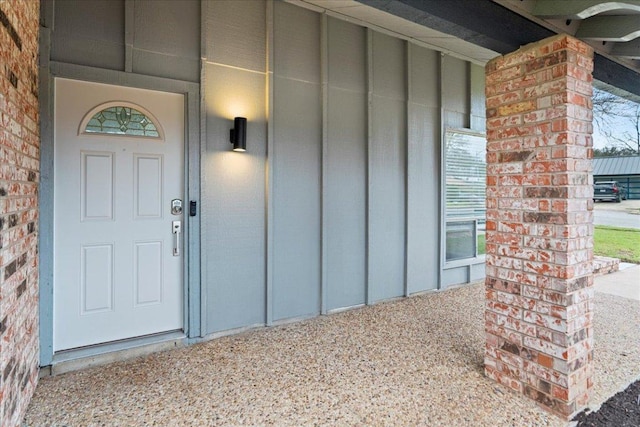 doorway to property featuring brick siding