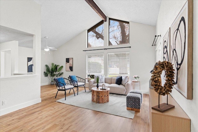 living area featuring baseboards, beam ceiling, wood finished floors, a textured ceiling, and high vaulted ceiling