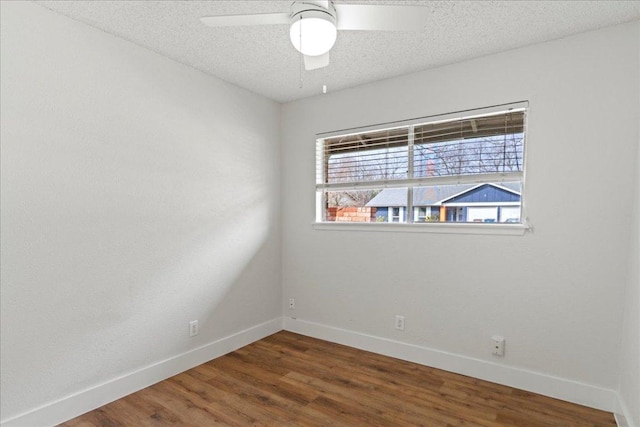 empty room featuring ceiling fan, baseboards, a textured ceiling, and wood finished floors