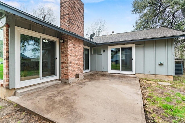 rear view of property featuring brick siding, board and batten siding, a chimney, and a patio