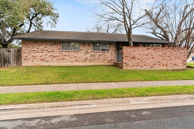 single story home featuring a front yard, fence, and brick siding