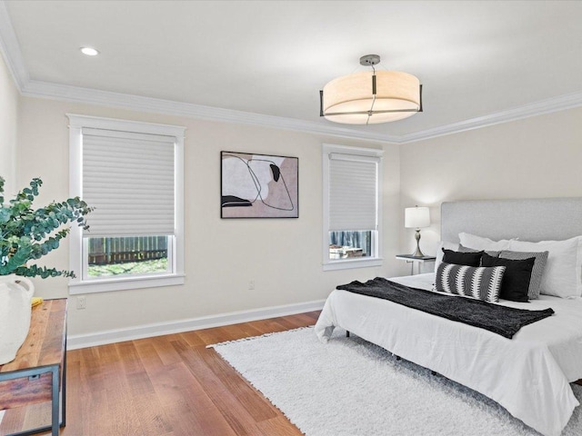 bedroom featuring recessed lighting, wood finished floors, baseboards, and ornamental molding