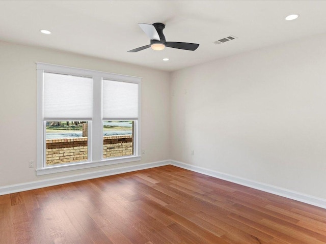 empty room with visible vents, recessed lighting, baseboards, and wood finished floors