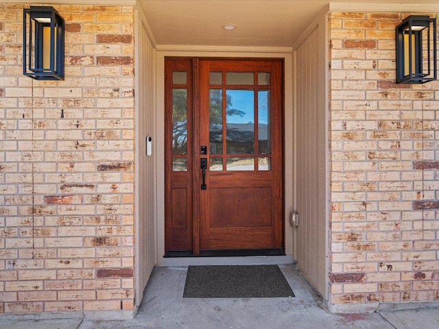 entrance to property featuring brick siding