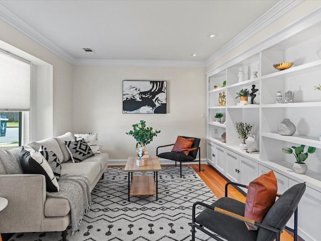 living room with visible vents, built in features, light wood-style floors, and ornamental molding